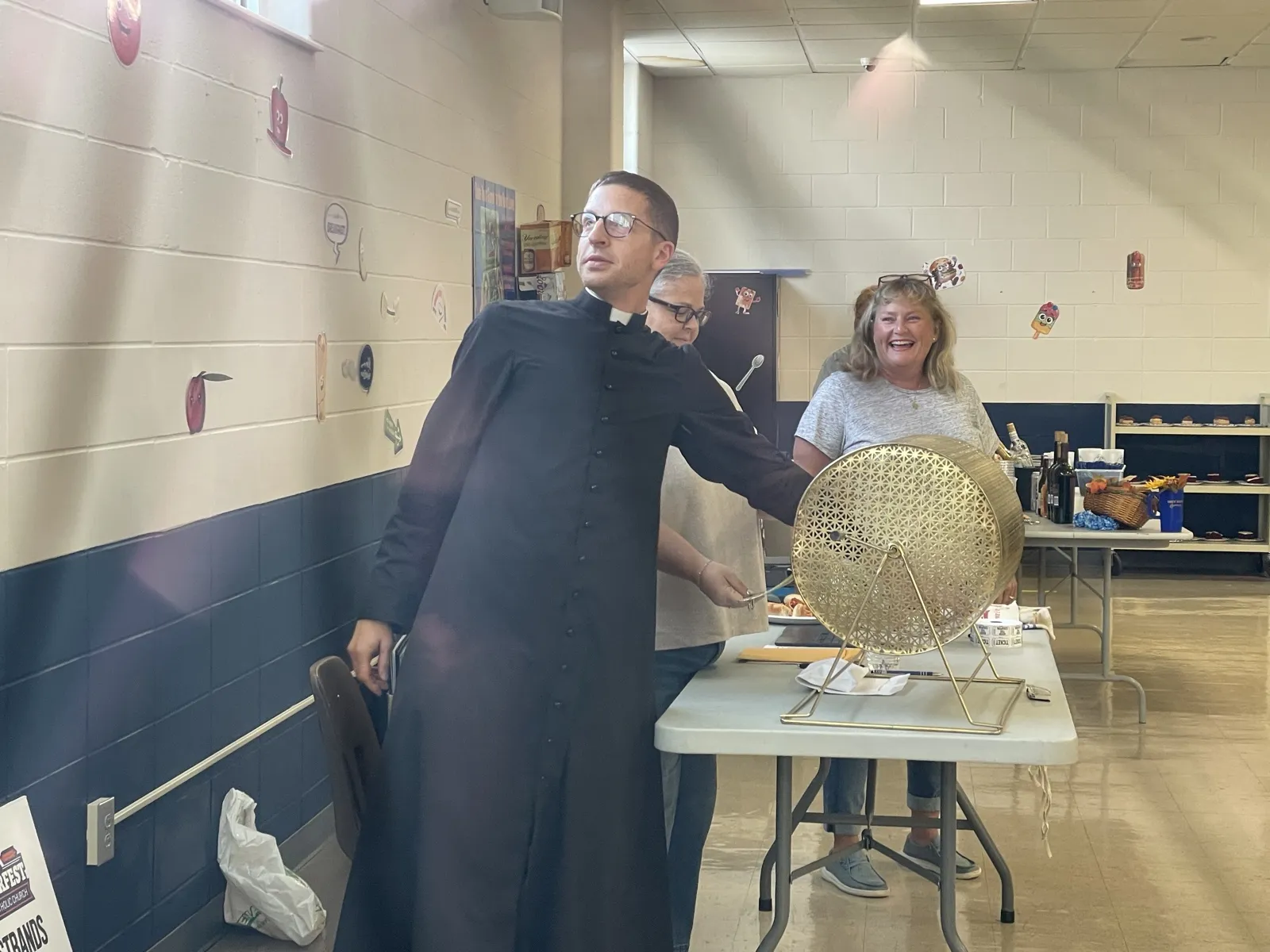 Father spinning the gold raffle drum to pull the early bird winners